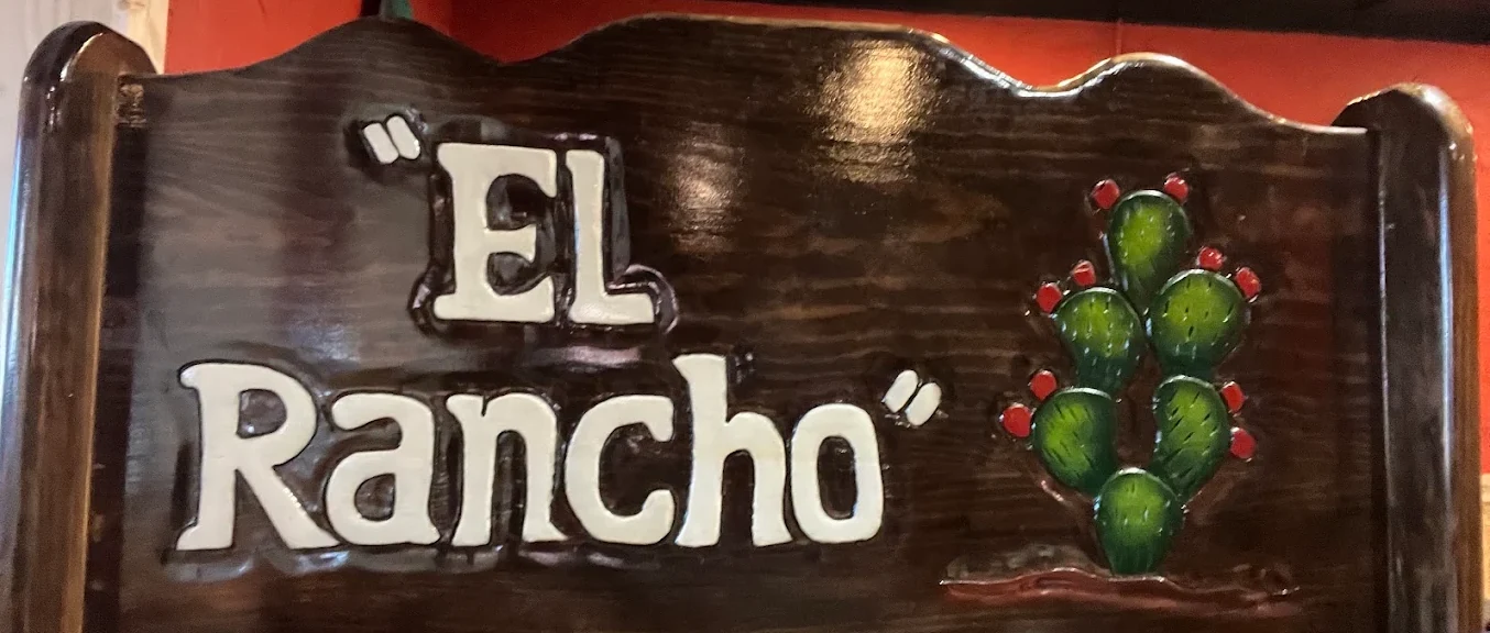The carved wooden El Rancho sign with its hand-painted prickly pear cactus